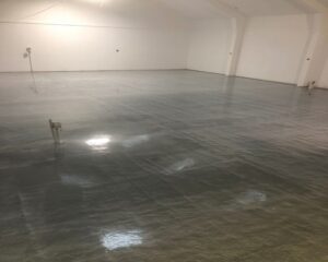 A freshly coated epoxy floor gleams in a newly painted commercial space